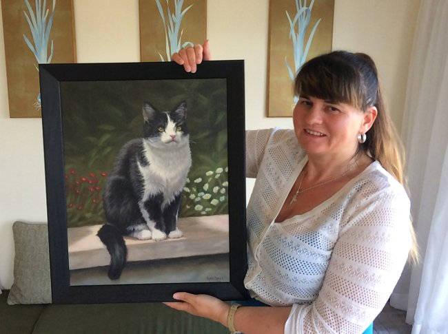 Client with pet portrait painting of a cat