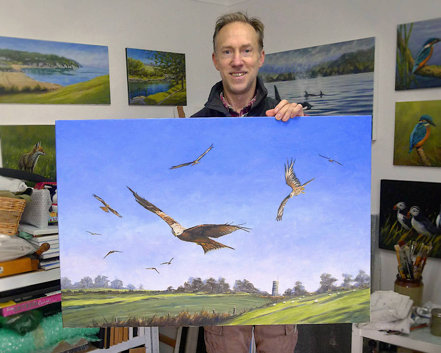 Artist chris chalk in his studio holding a Large red kite painting